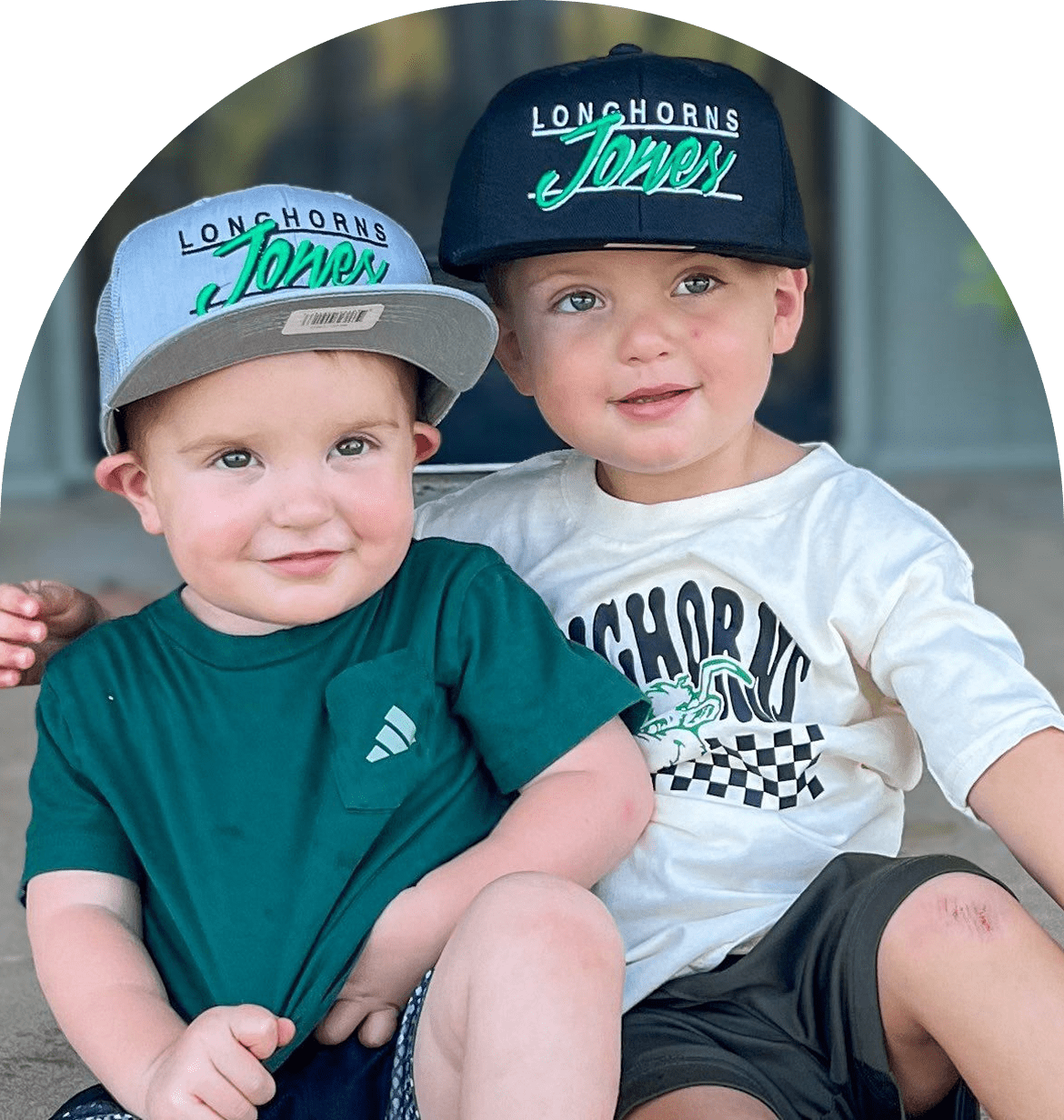 Two young children wearing matching hats.
